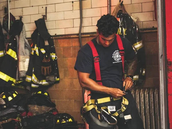 Bombero revisando y ajustando su equipo antes de salir
