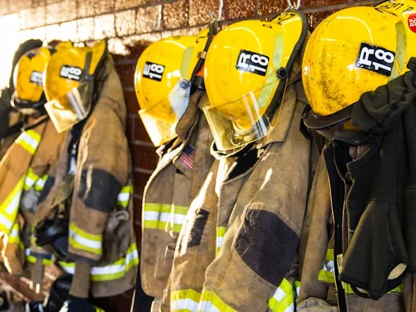 Chaquetones y cascos de bombero colgados en la estación