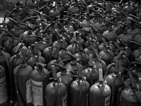 Extintores portátiles alineados en almacén antes de su distribución
