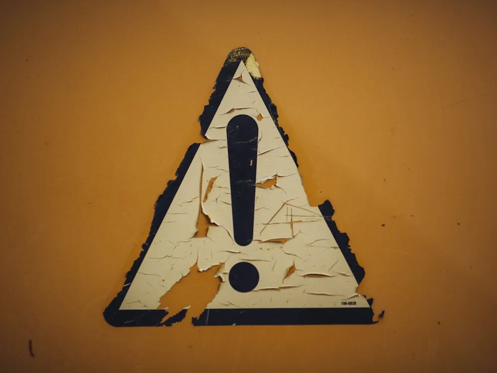 Señal triangular de advertencia de riesgo en instalación industrial