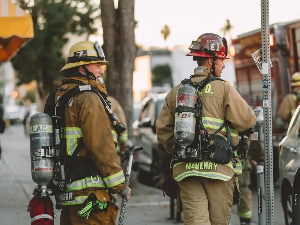Dos bomberos con equipo de respiración autónoma y cilindros SCBA