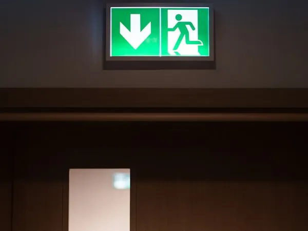 Señal verde iluminada de salida sobre una puerta de evacuación