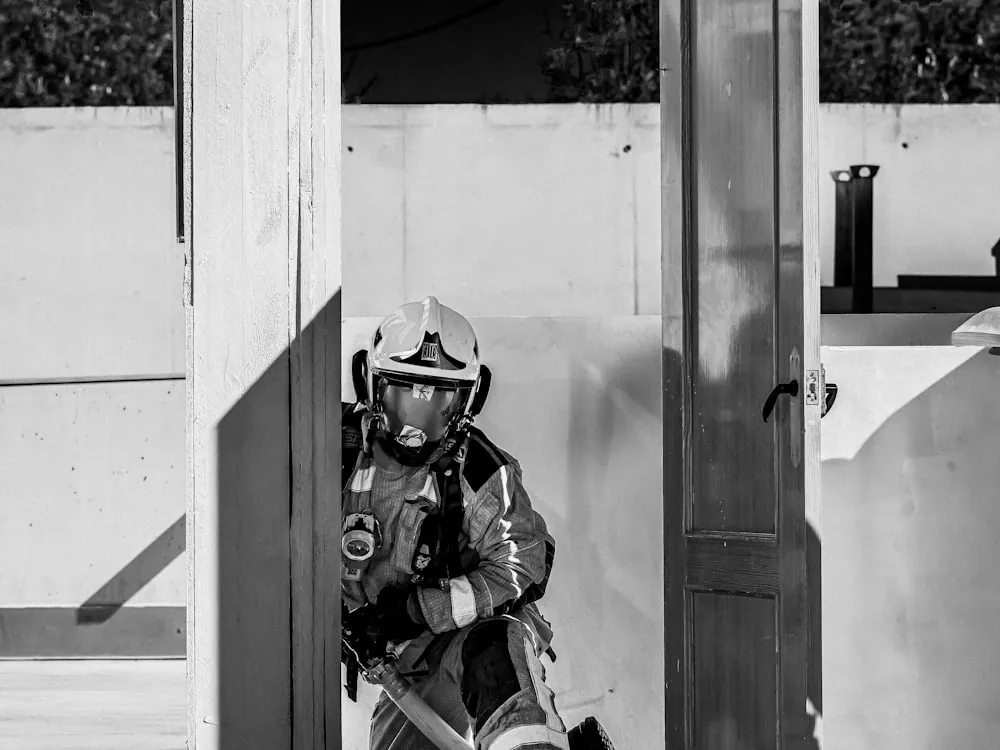 Bombero equipado saliendo de una estructura durante una maniobra de rescate