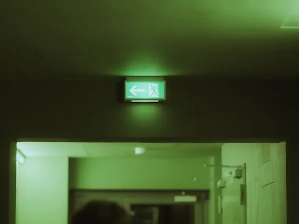 Corredor iluminado por alumbrado de emergencia con señalización visible