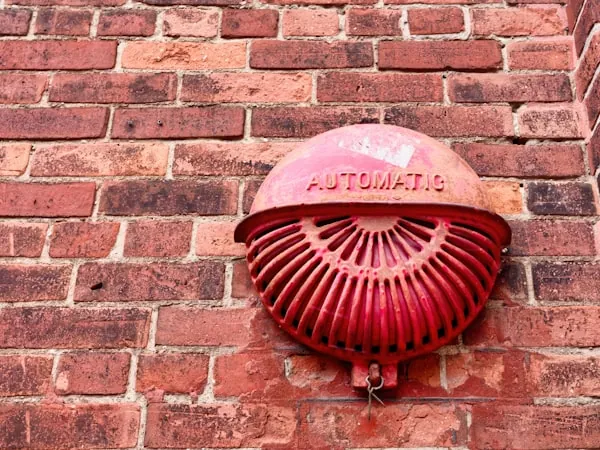 Campana de alarma contra incendio montada en muro de ladrillo