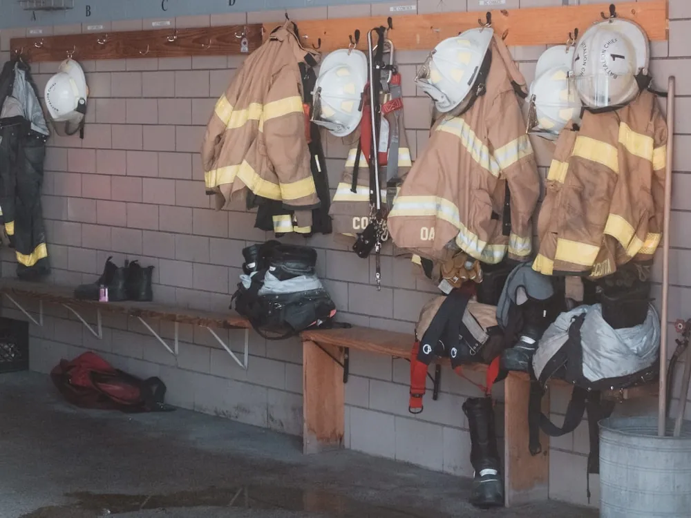 Trajes estructurales y cascos colgados en el vestidor de la estación